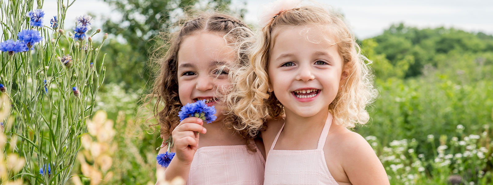 Photo of sisters in a meadow by Southern Pennsylvania and Philadelphia family photographer Tara Lynn of Silver Orchid Photography